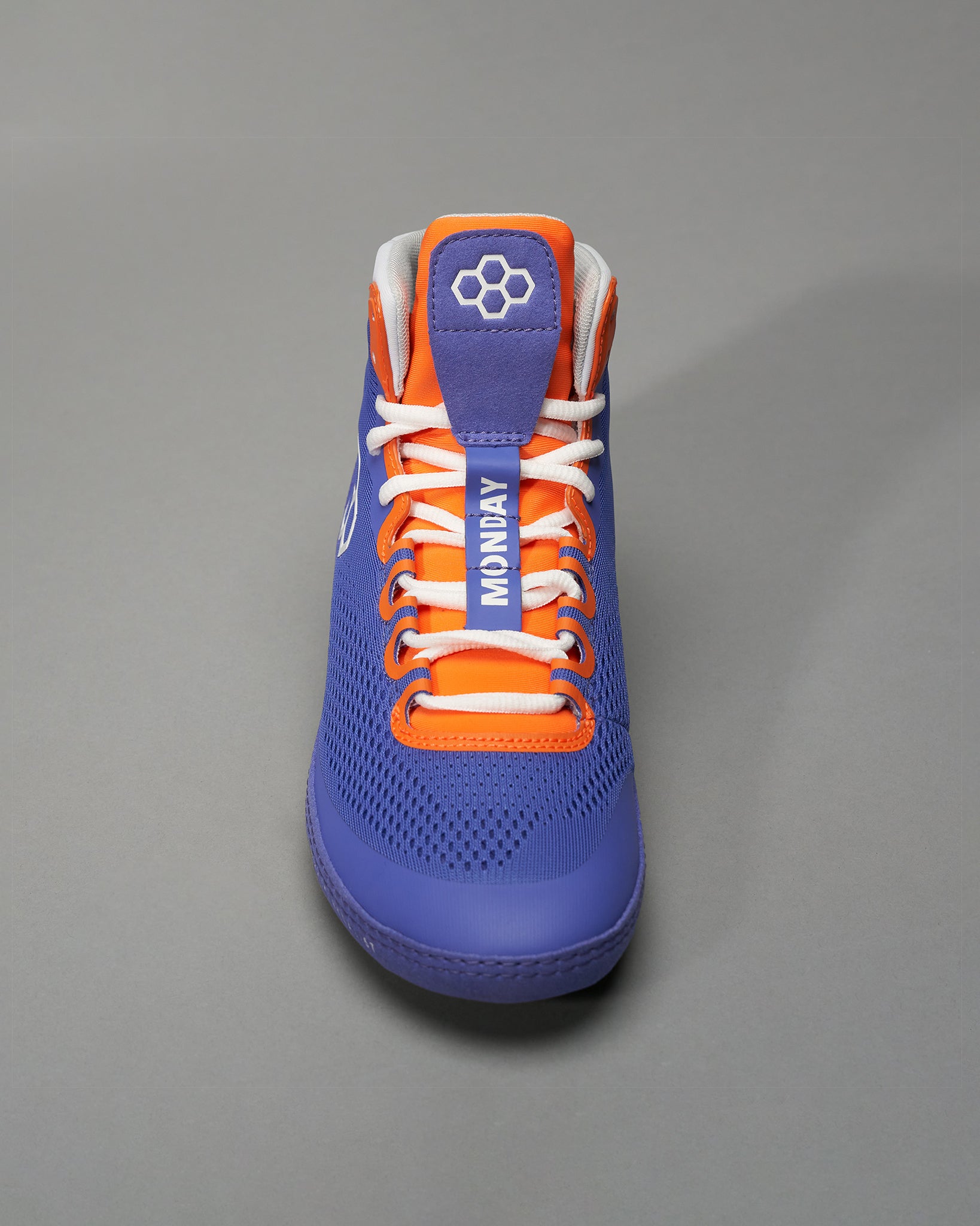 This sneaker features a vibrant purple design with orange accents and highlights the word MONDAY on the tongue designed for sport and casual wear