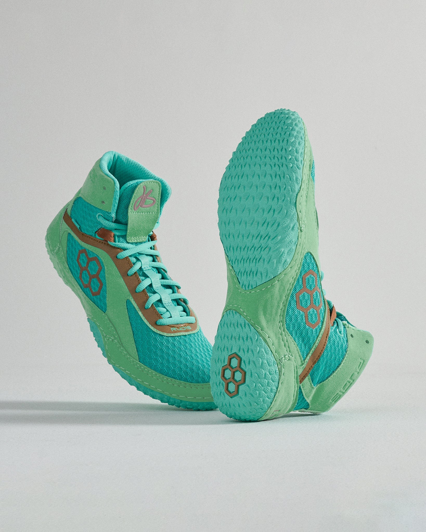 High-top athletic shoe in vibrant aqua showcasing textured features and a multi-patterned sole for optimal traction against a soft gray background.