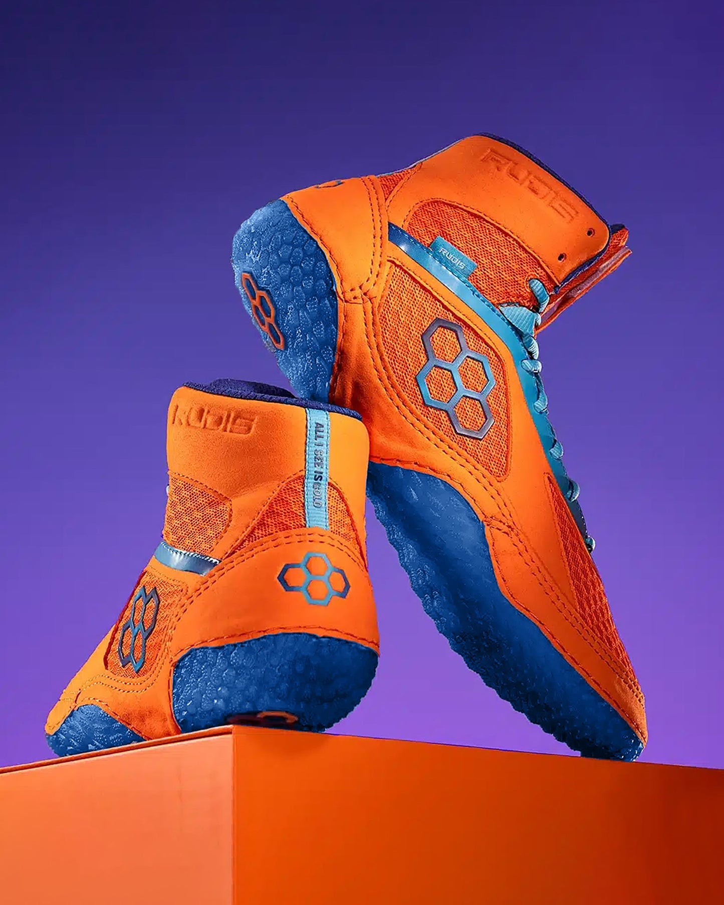 A pair of high-top orange athletic shoes with blue soles is showcased on an orange pedestal, set against a purple background, fusing functionality and style.