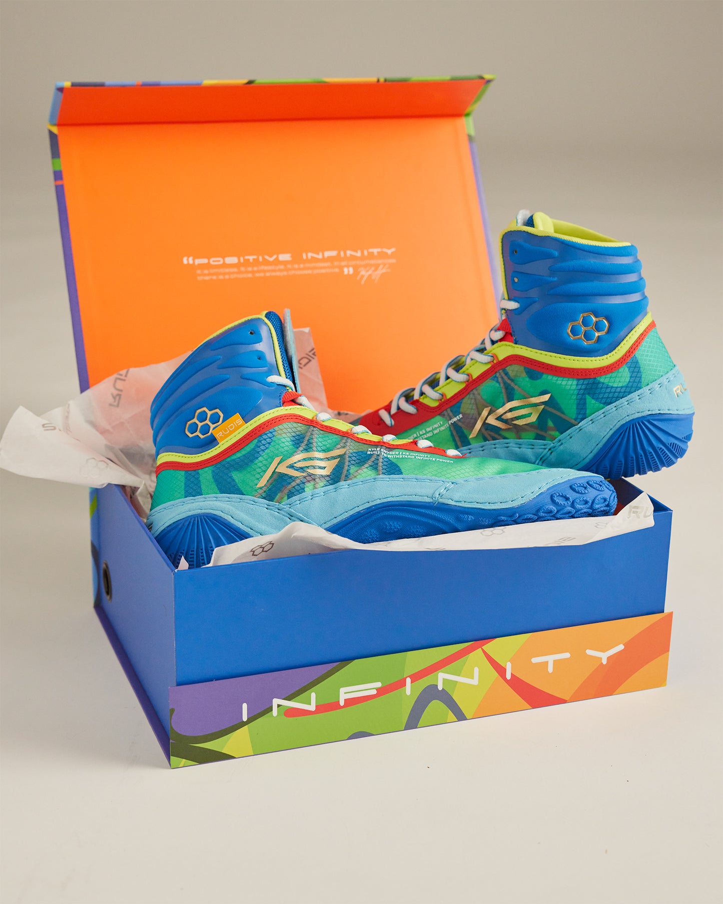 A vibrant pair of blue and green athletic shoes displayed in an open colorful box showcasing their unique design and branding