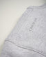 A close-up view of a gray sweatshirt sleeve featuring the phrase A WAY OF LIFE printed on it highlighting its soft texture and seam details