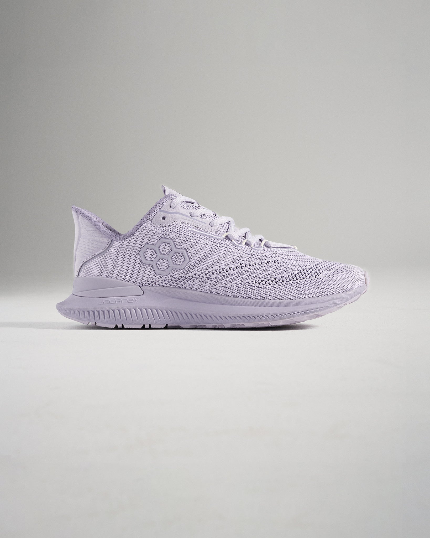 A side view of a light purple running shoe featuring a breathable mesh upper and a textured sole designed for comfort and performance