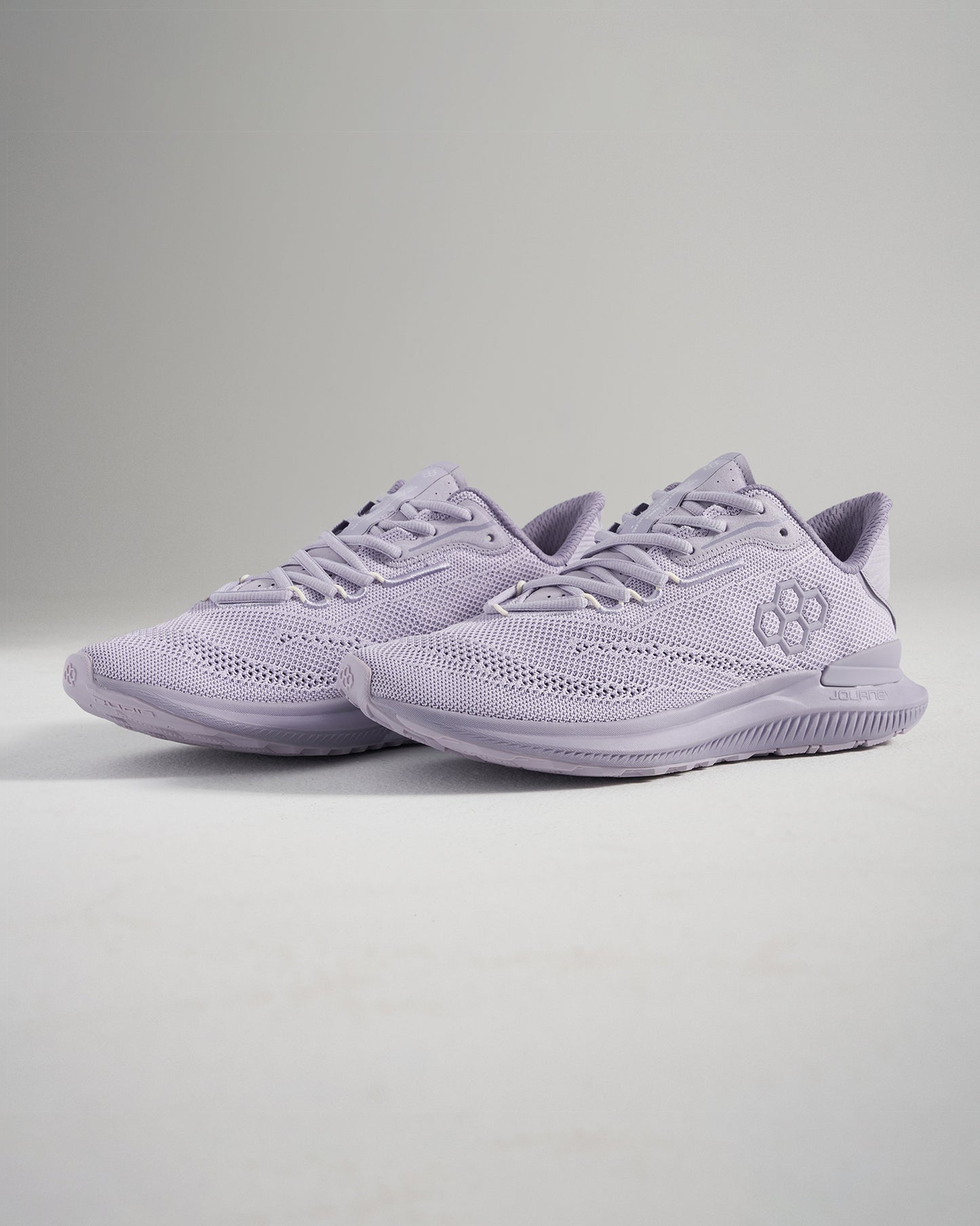 A pair of light purple athletic shoes with a breathable mesh upper and a textured sole for running and training activities