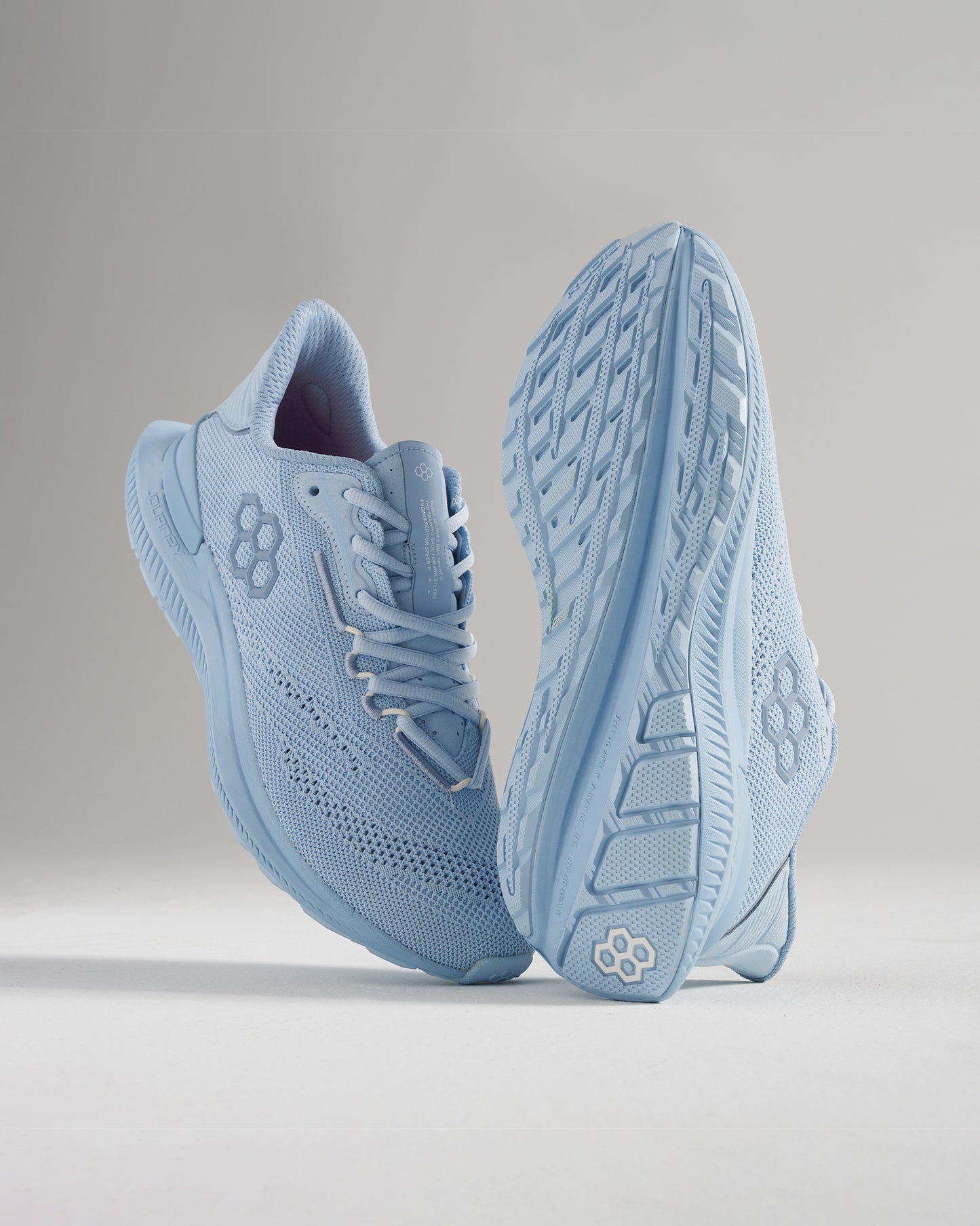 A pair of light blue athletic shoes showcasing a modern design with breathable mesh upper and textured grip soles