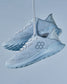 Light blue athletic shoes with a breathable mesh upper and a textured sole stylishly suspended against a soft blue background