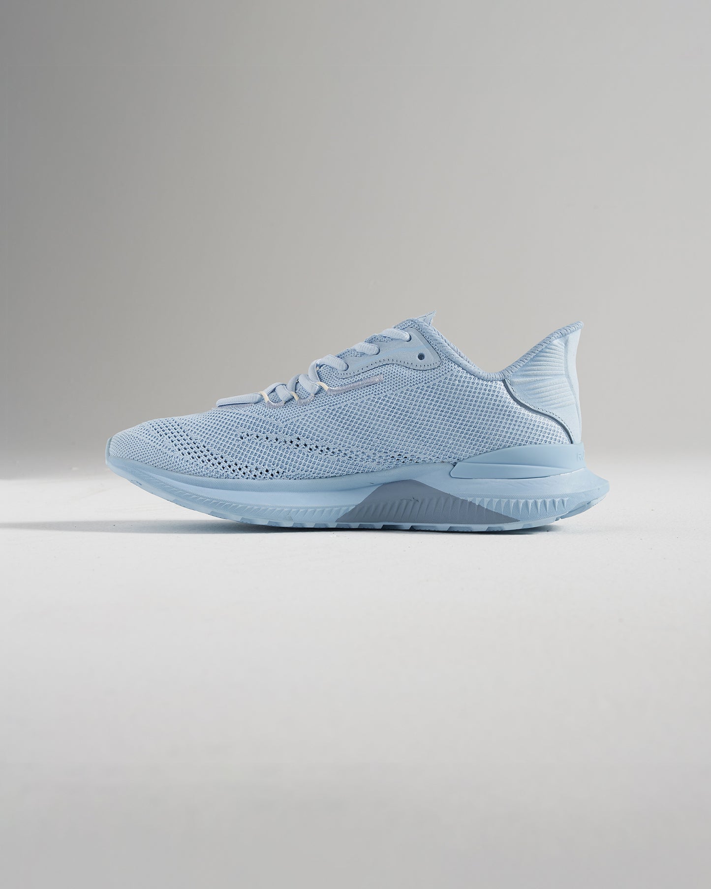 A side view of a light blue running shoe featuring a breathable mesh upper and a textured sole for enhanced grip