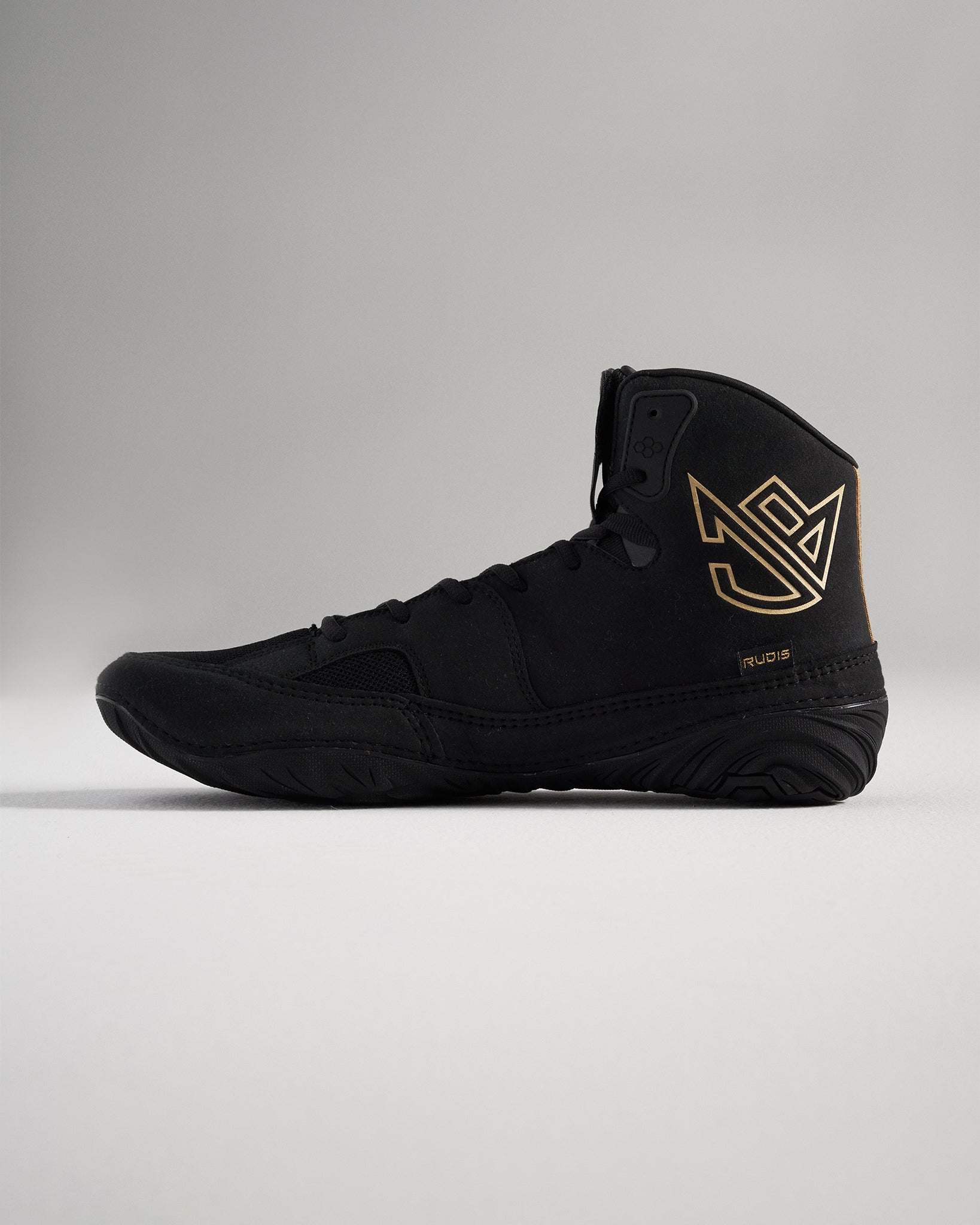 A sleek black wrestling shoe featuring gold accents designed for performance and support in athletic settings