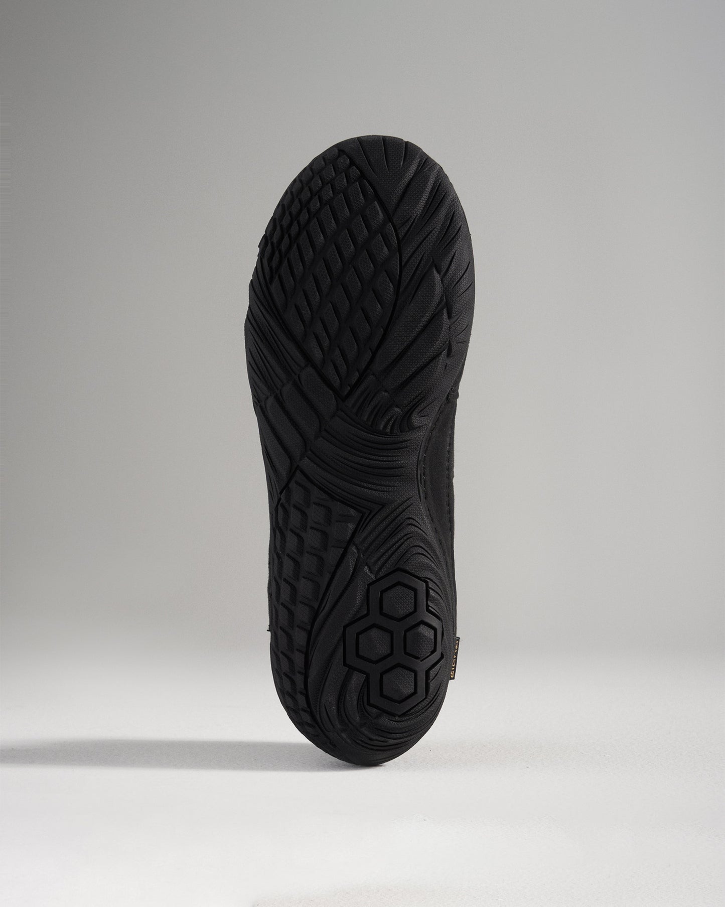 A detailed view of a black athletic shoe sole showcasing its textured tread design and grip features