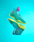 This image features stylish turquoise basketball shoes with vibrant accents designed for performance and aesthetics floating against a bright blue backdrop