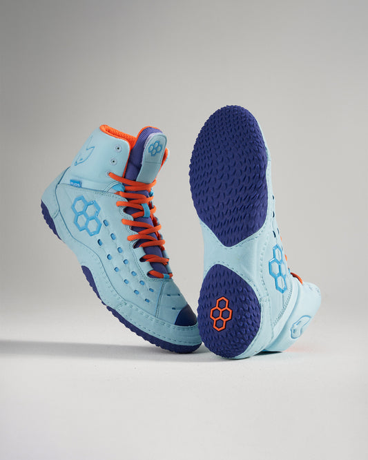 This image features a pair of light blue high-top athletic shoes with vibrant orange and purple accents designed for optimal performance and style