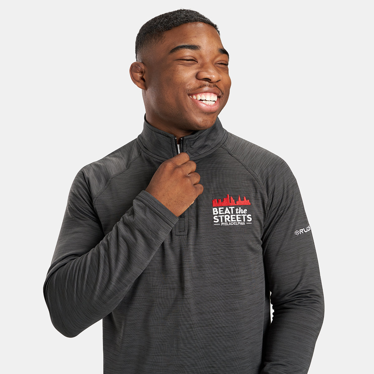 A young man wearing a zippered athletic jacket with a smiling expression promoting the Beat the Streets initiative in Philadelphia