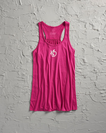 A vibrant pink tank top with a sporty design featuring a stylized logo at the front set against a textured gray background