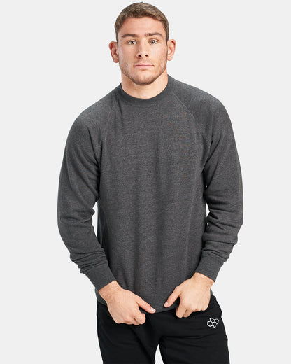 A young man wearing a dark gray long-sleeve shirt poses with a neutral expression against a light gray background