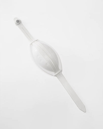 A white silicone wristband designed to resemble an egg featuring a smooth oval shape and a snap closure for secure wear