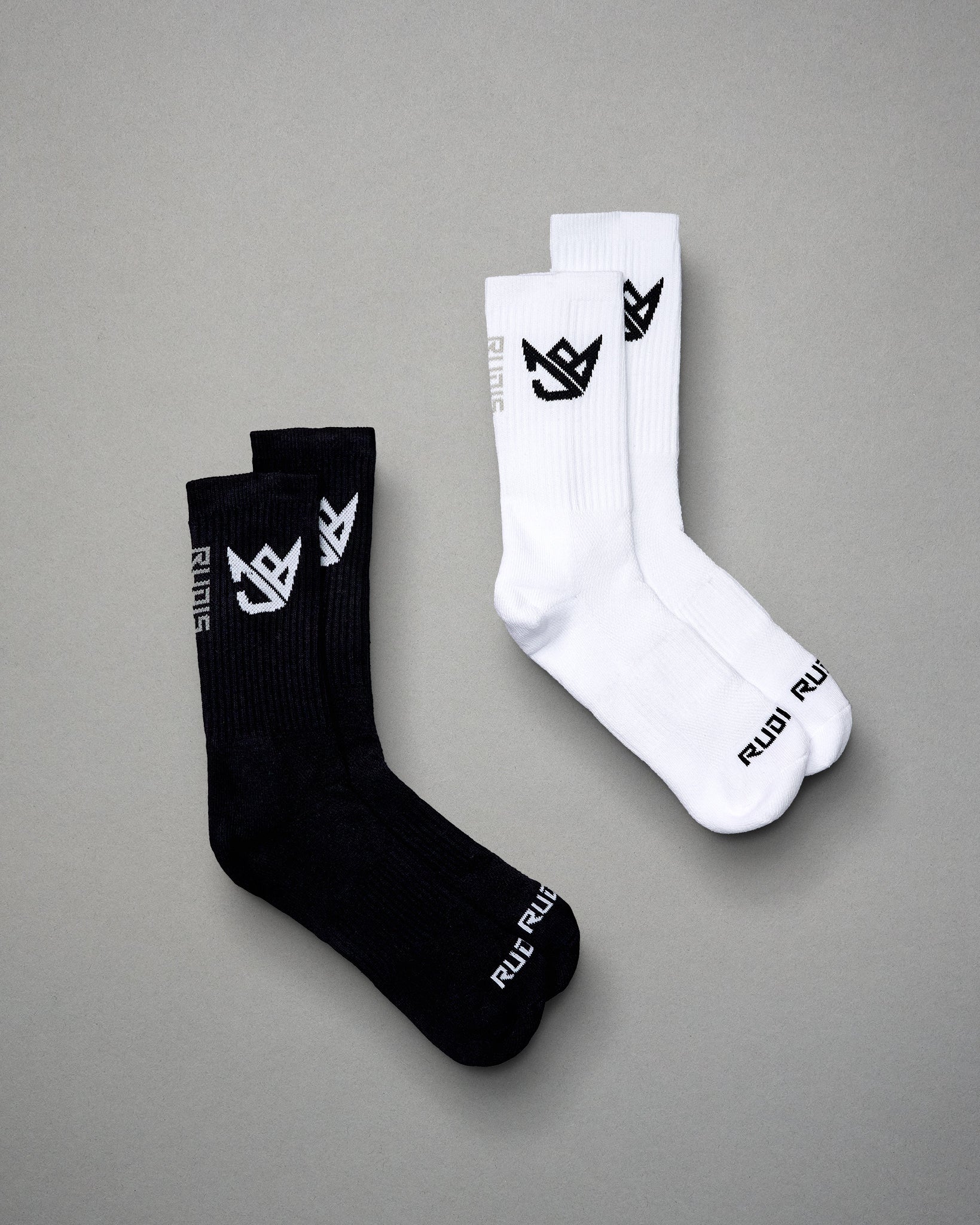 A pair of black and white athletic socks featuring ribbed texture and logo details ideal for sports and casual wear