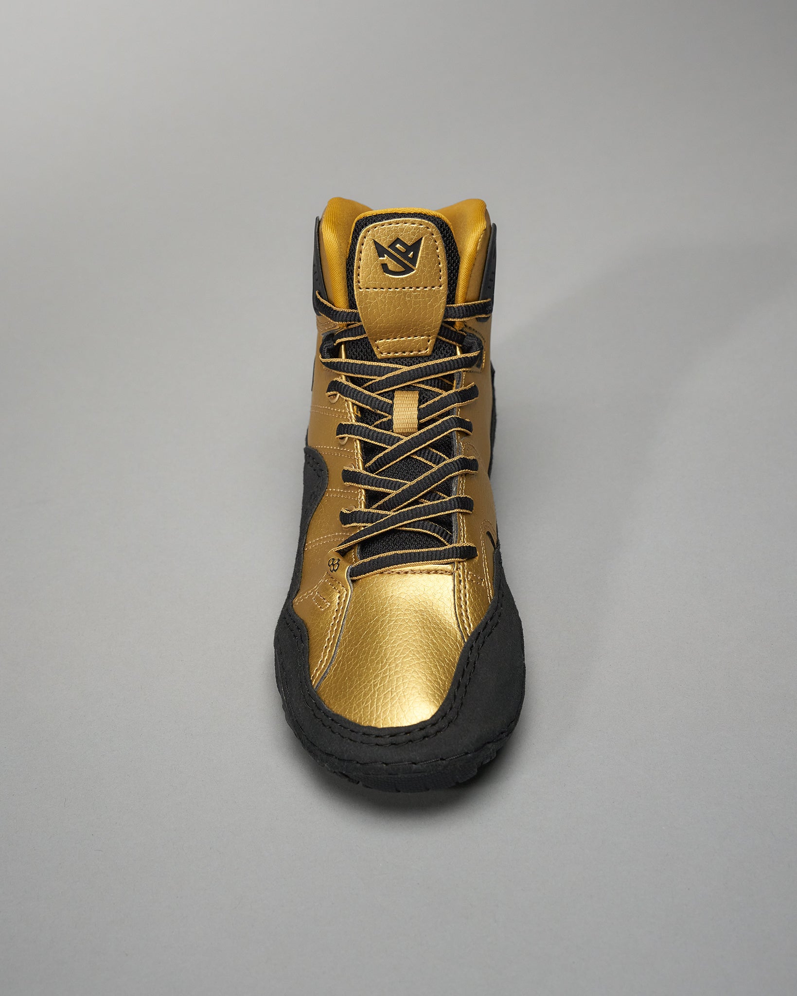 This image features a high-top athletic shoe designed with a striking gold and black color scheme highlighting its modern design and performance-oriented features