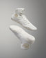 White high-top sneakers with textured design and gold accents are seen floating against a soft gray background, showcasing their athletic features.