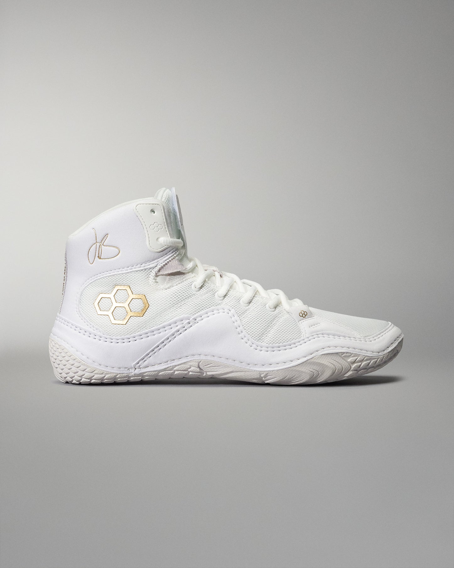 A high-top athletic shoe in white with gold accents includes a padded collar and textured sole, presented against a light gray background.