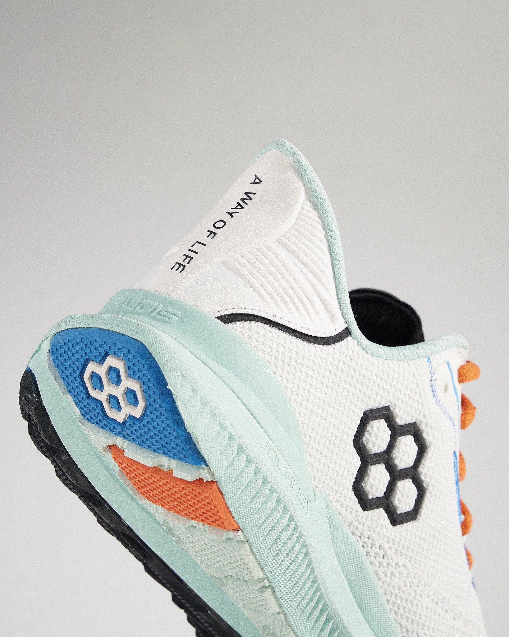 A stylish athletic shoe featuring a modern design with a breathable white mesh upper and multi-colored sole accents