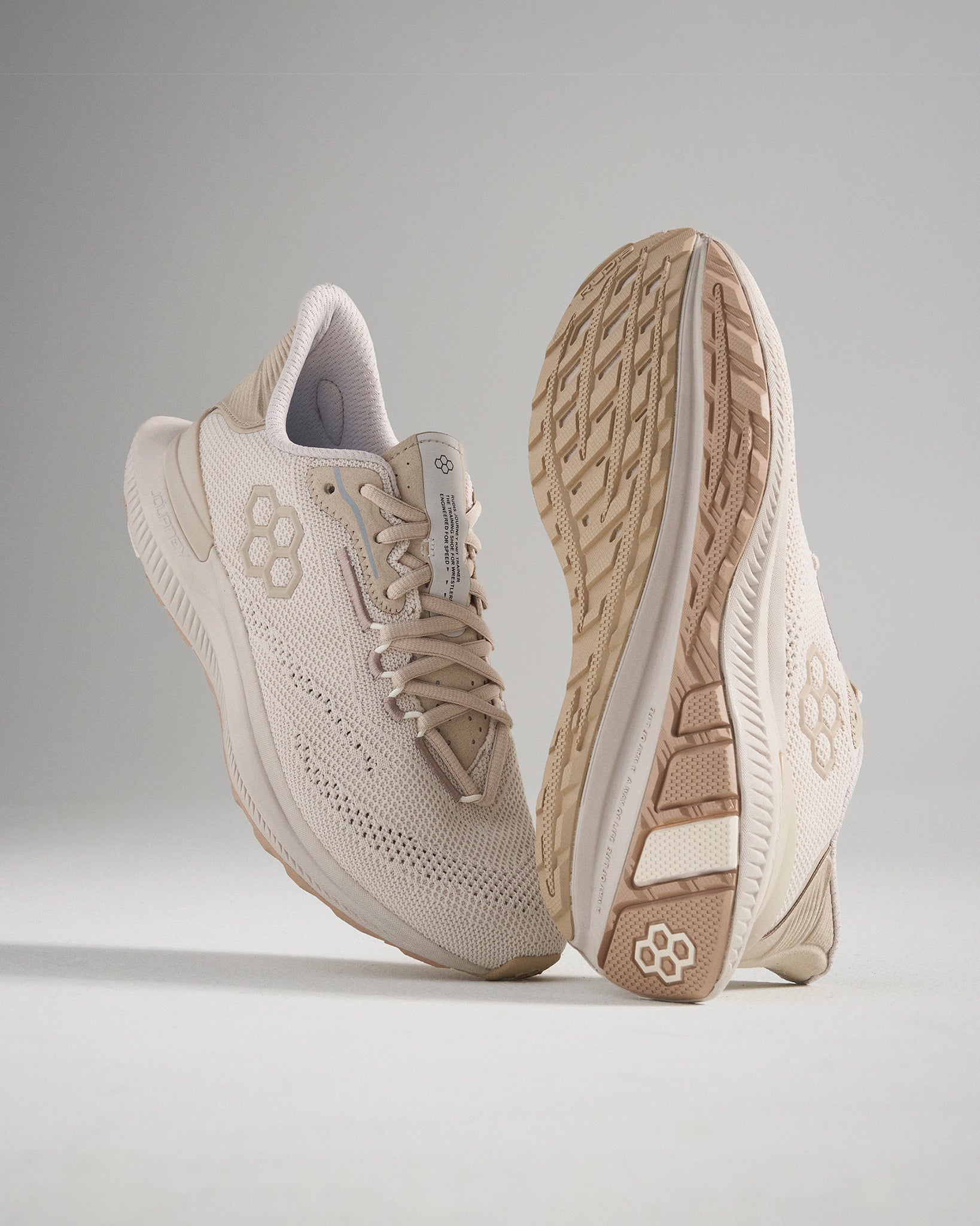 A pair of light beige running shoes featuring a breathable mesh upper and a textured sole for enhanced grip and support