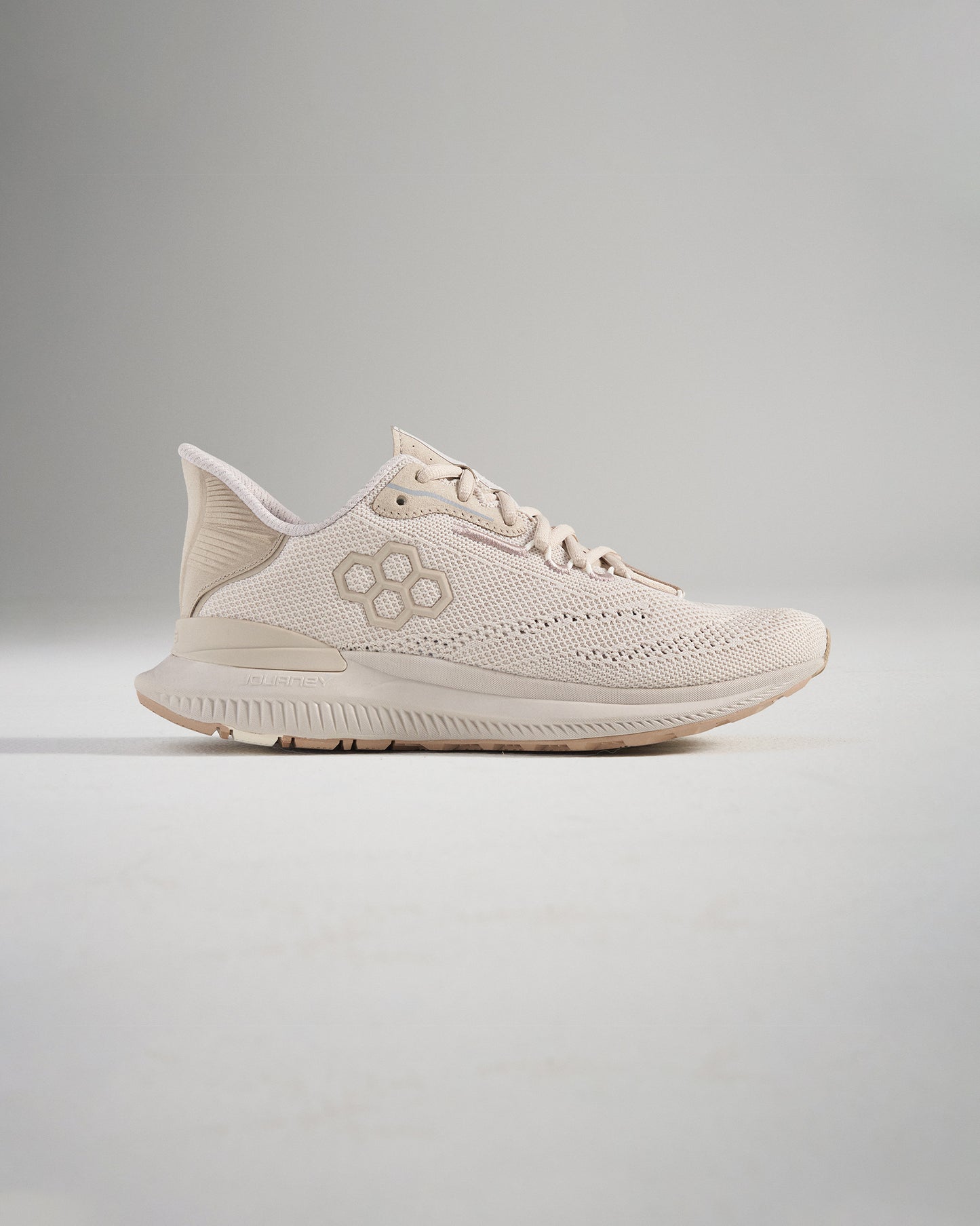 A modern beige athletic shoe featuring a breathable mesh upper and a lightweight sole designed for performance and style