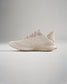 A stylish beige running shoe featuring a breathable mesh upper and a textured sole designed for comfort and performance