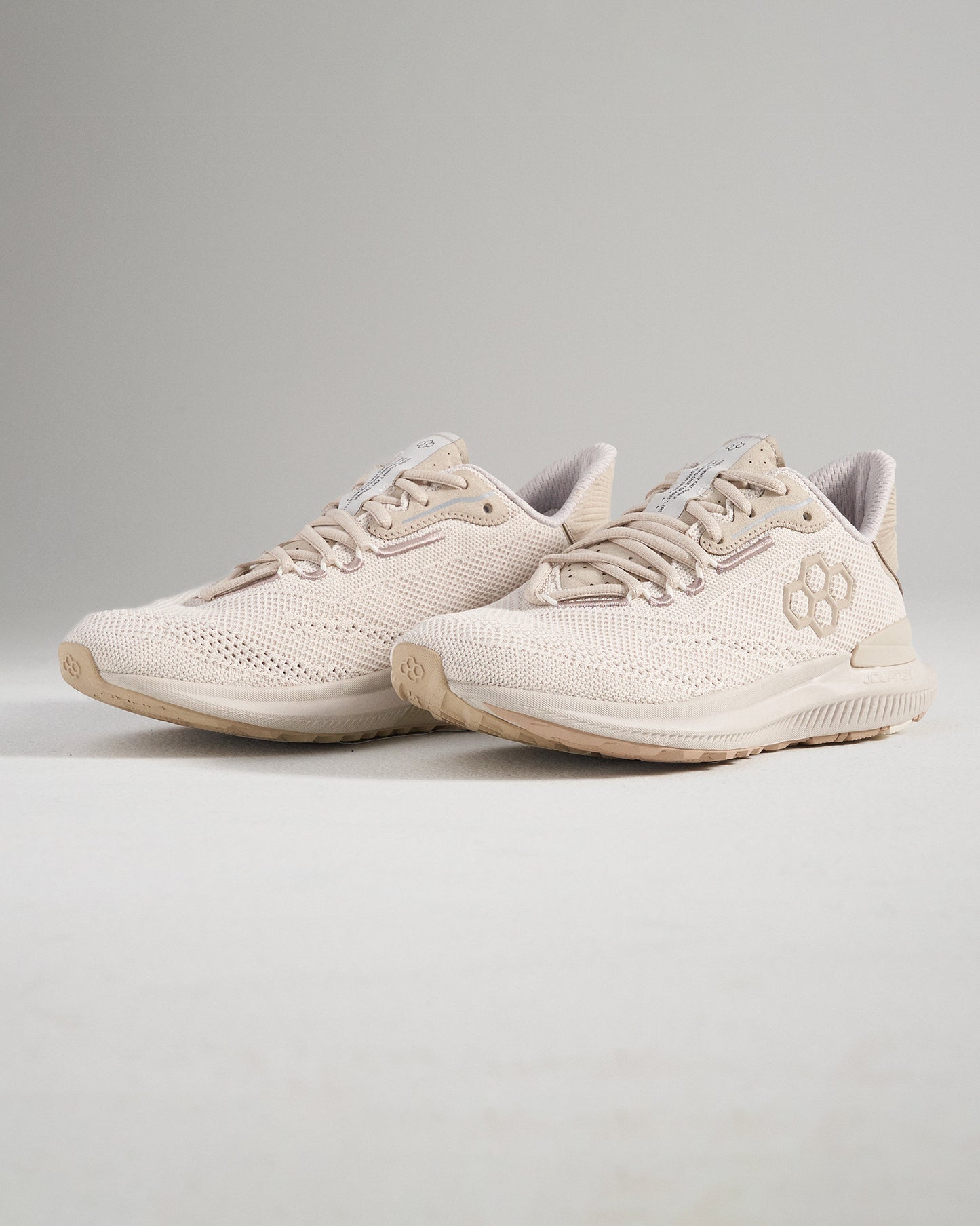 Light beige running shoes featuring a breathable mesh upper and textured sole designed for comfort and performance