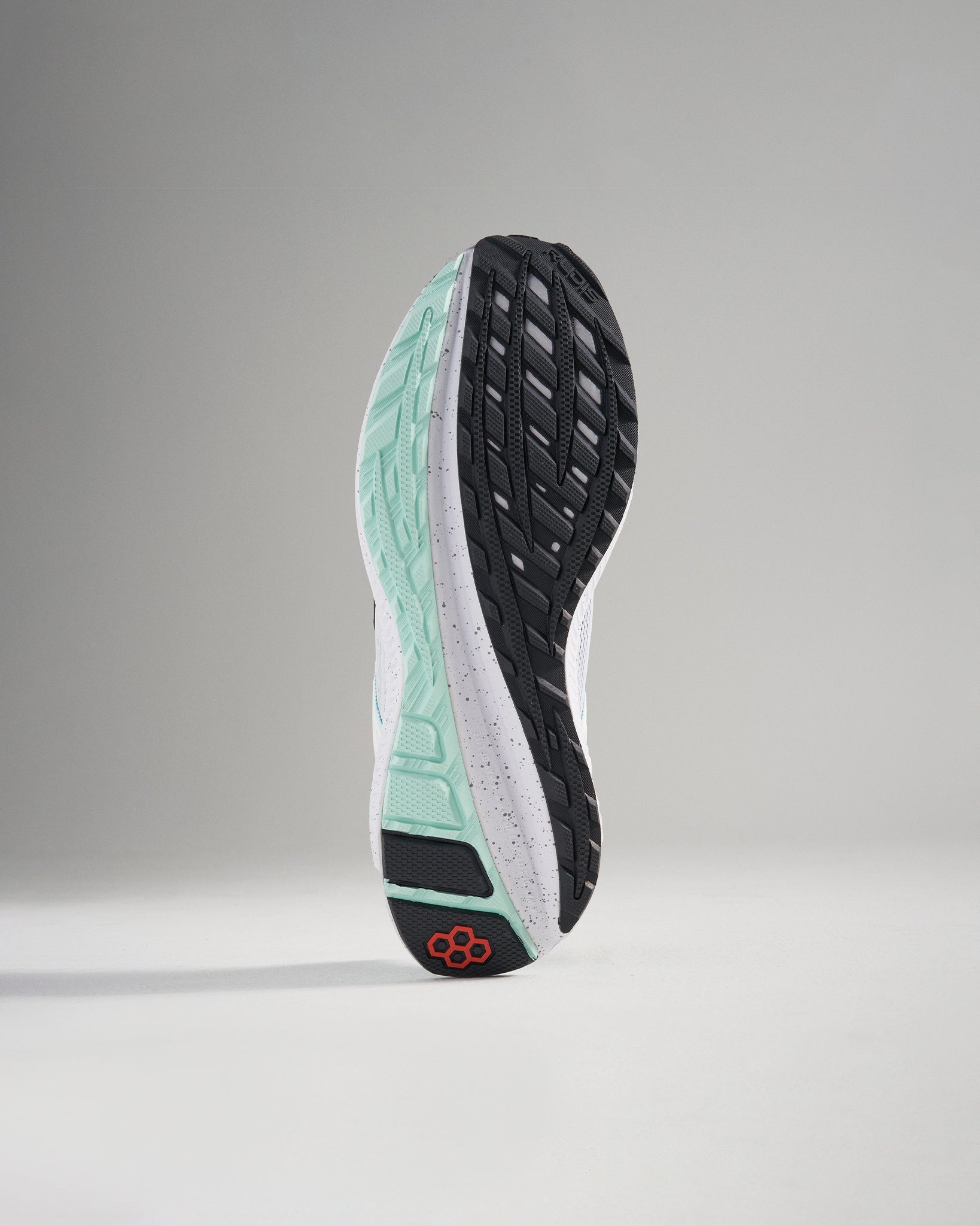 This image showcases the sole of a modern running shoe featuring a sleek design with distinctive tread patterns and vibrant color accents