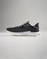 A side view of a modern black athletic shoe with a sleek design featuring breathable mesh and a durable sole