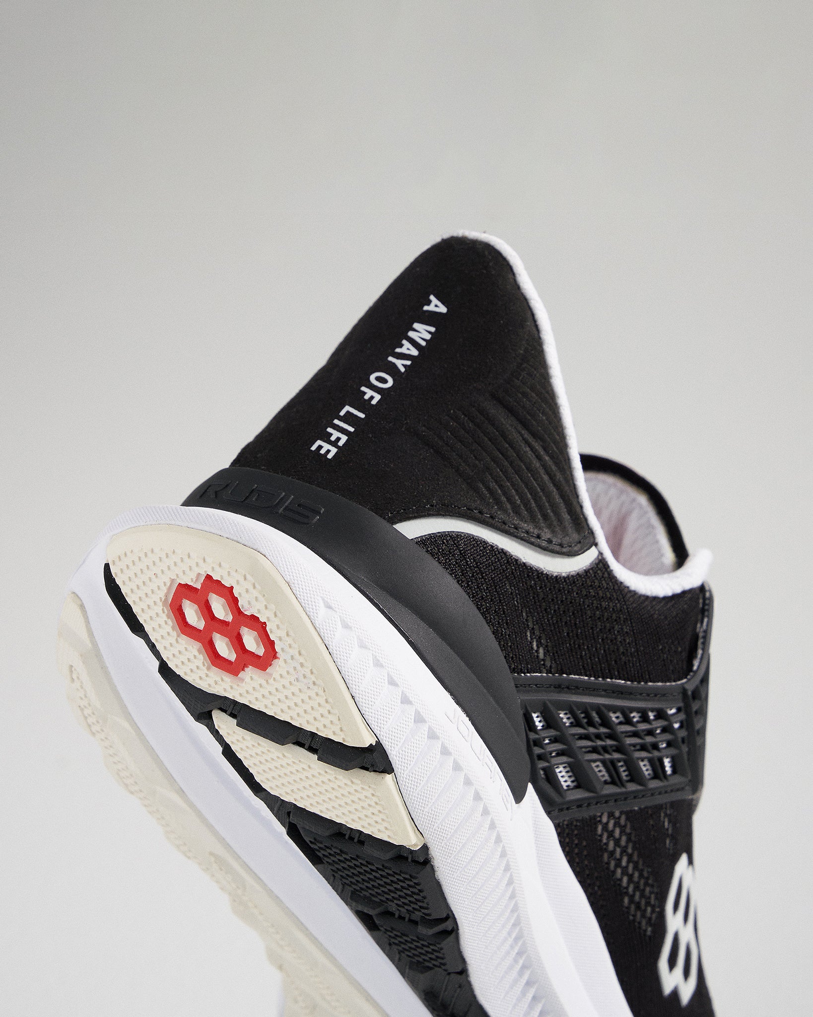 A close-up view of a black athletic shoe featuring a sleek design with a prominent logo and dynamic sole pattern