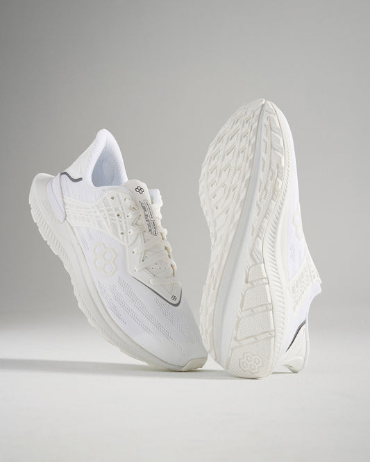 A pair of modern white athletic shoes showcasing a sleek design and textured detail on the upper and sole