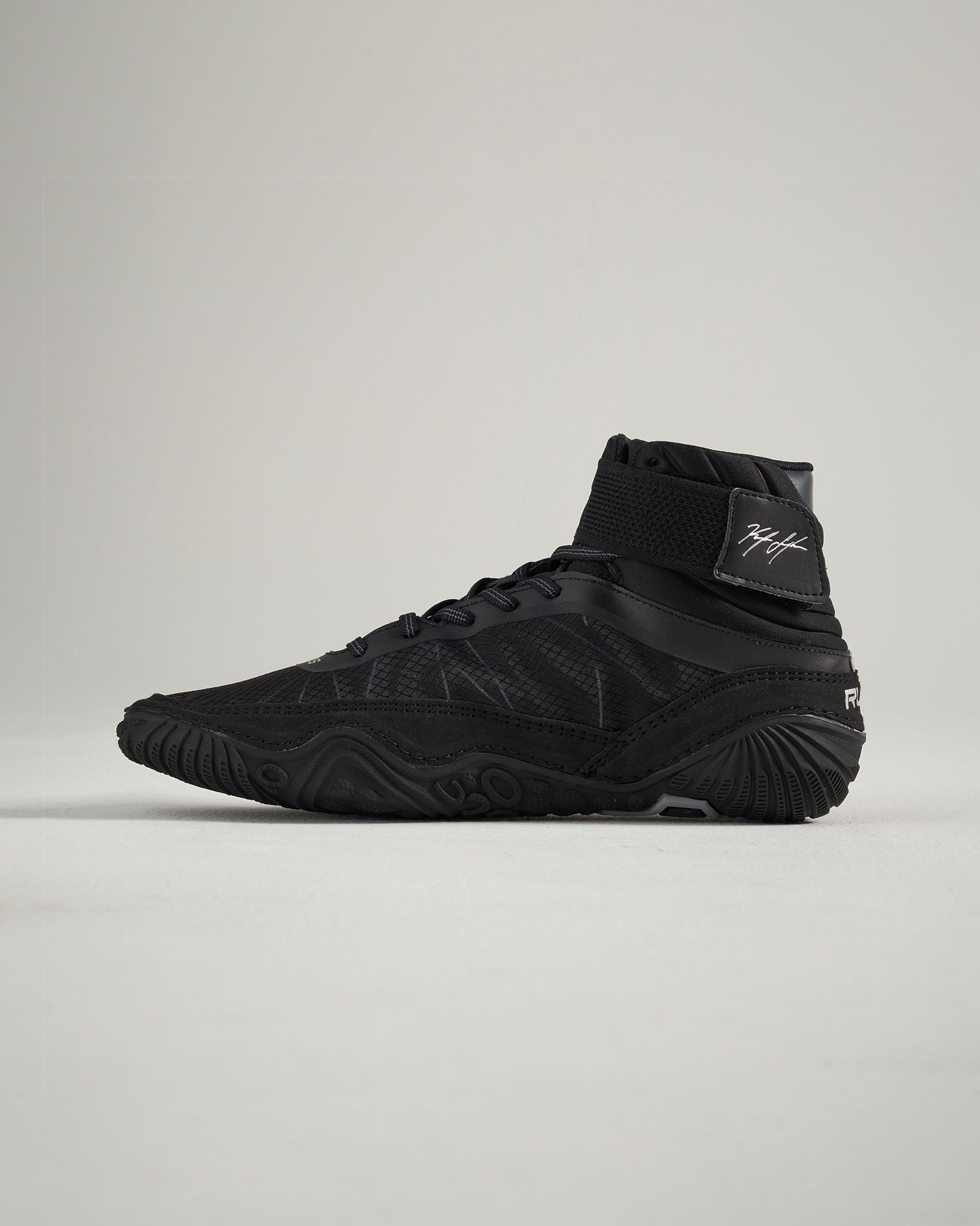 A sleek black athletic shoe featuring a high-top design textured surface and durable sole for performance and stability