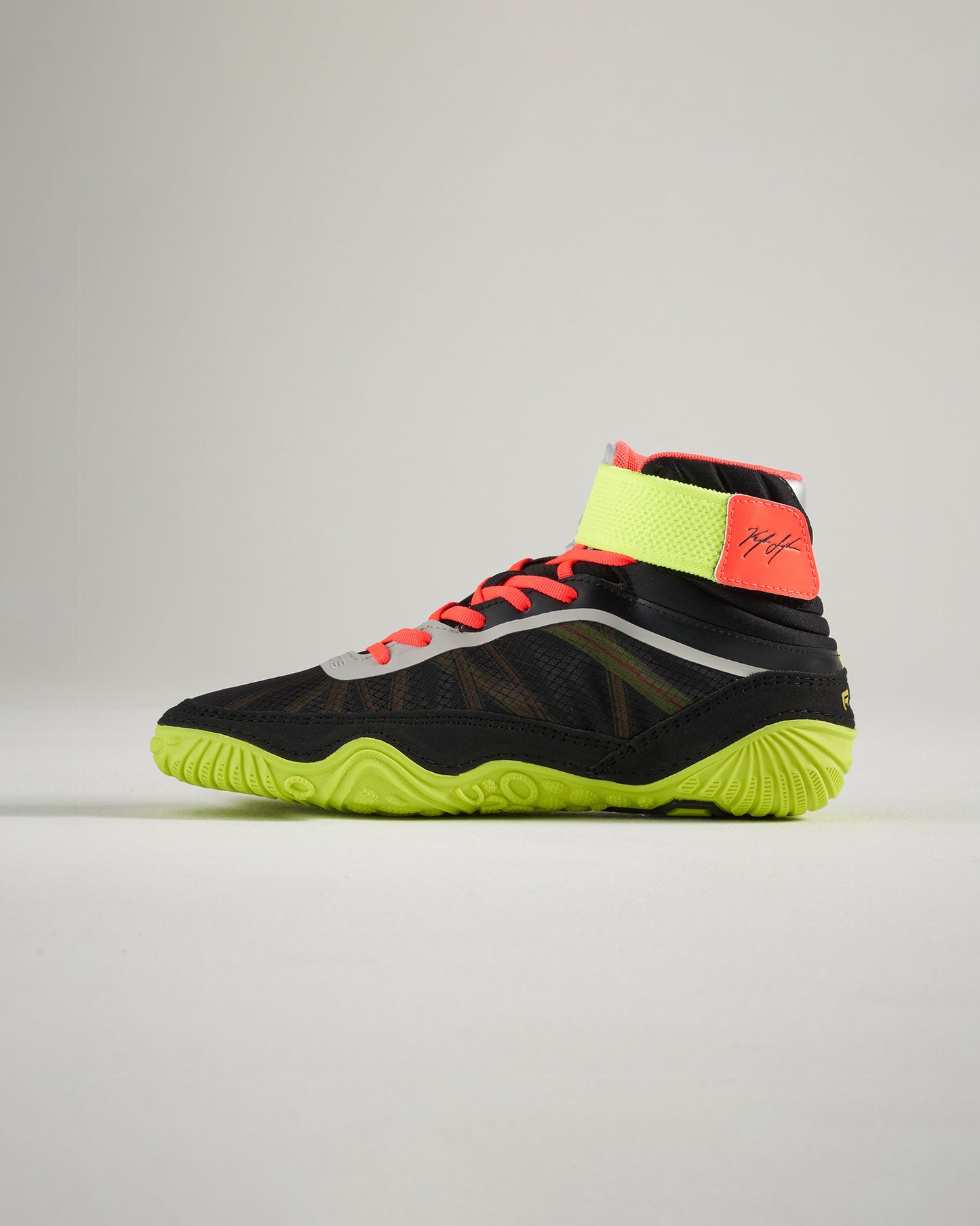 This sleek black athletic shoe features vibrant neon green soles and a supportive high-top design perfect for active wear