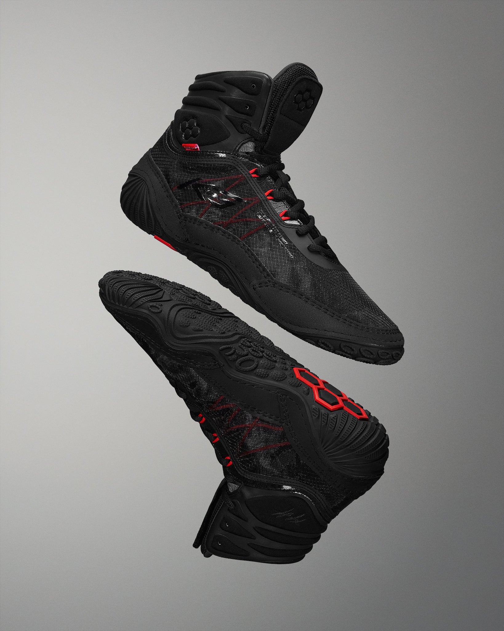 High-performance black athletic shoes, designed for grip and support, showcase a breathable upper and textured sole against a soft gray background.