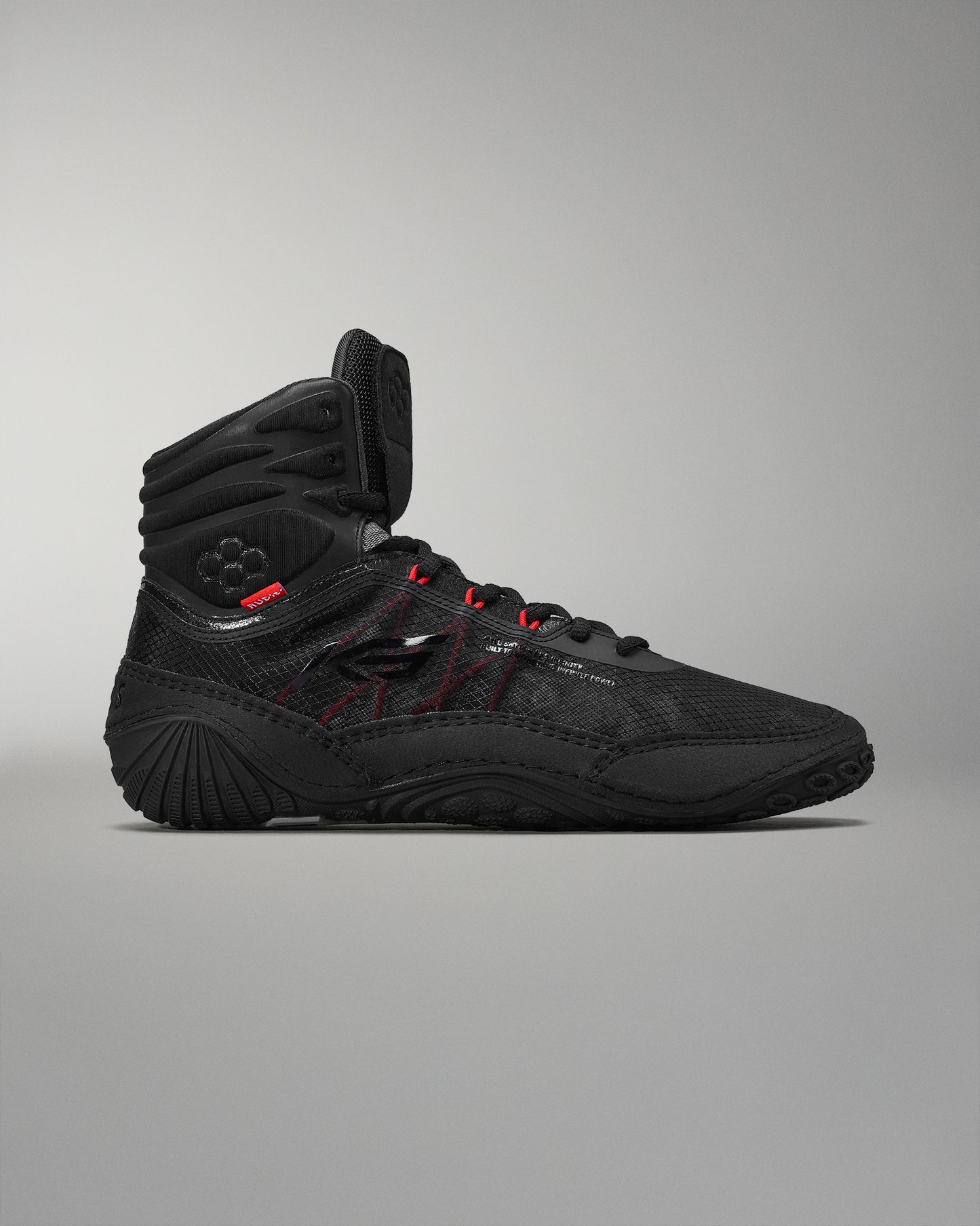 High-top athletic shoe in black with red accents, featuring a textured surface for grip, padded collar for comfort, and a durable design suited for athletic activities.