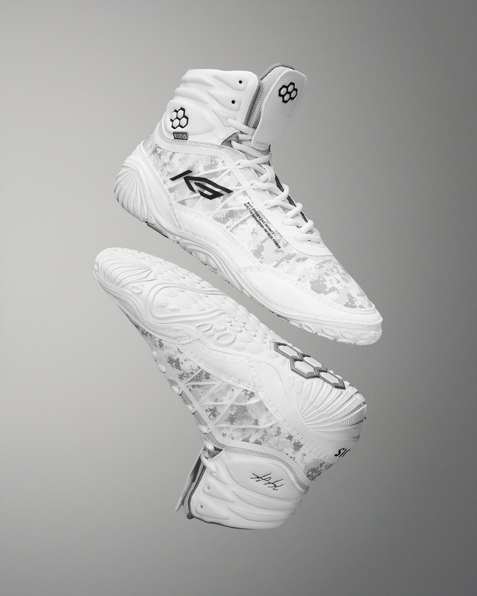 High-top athletic shoes in white, featuring a camouflage pattern and a textured sole for traction, highlighted against a soft gray background.