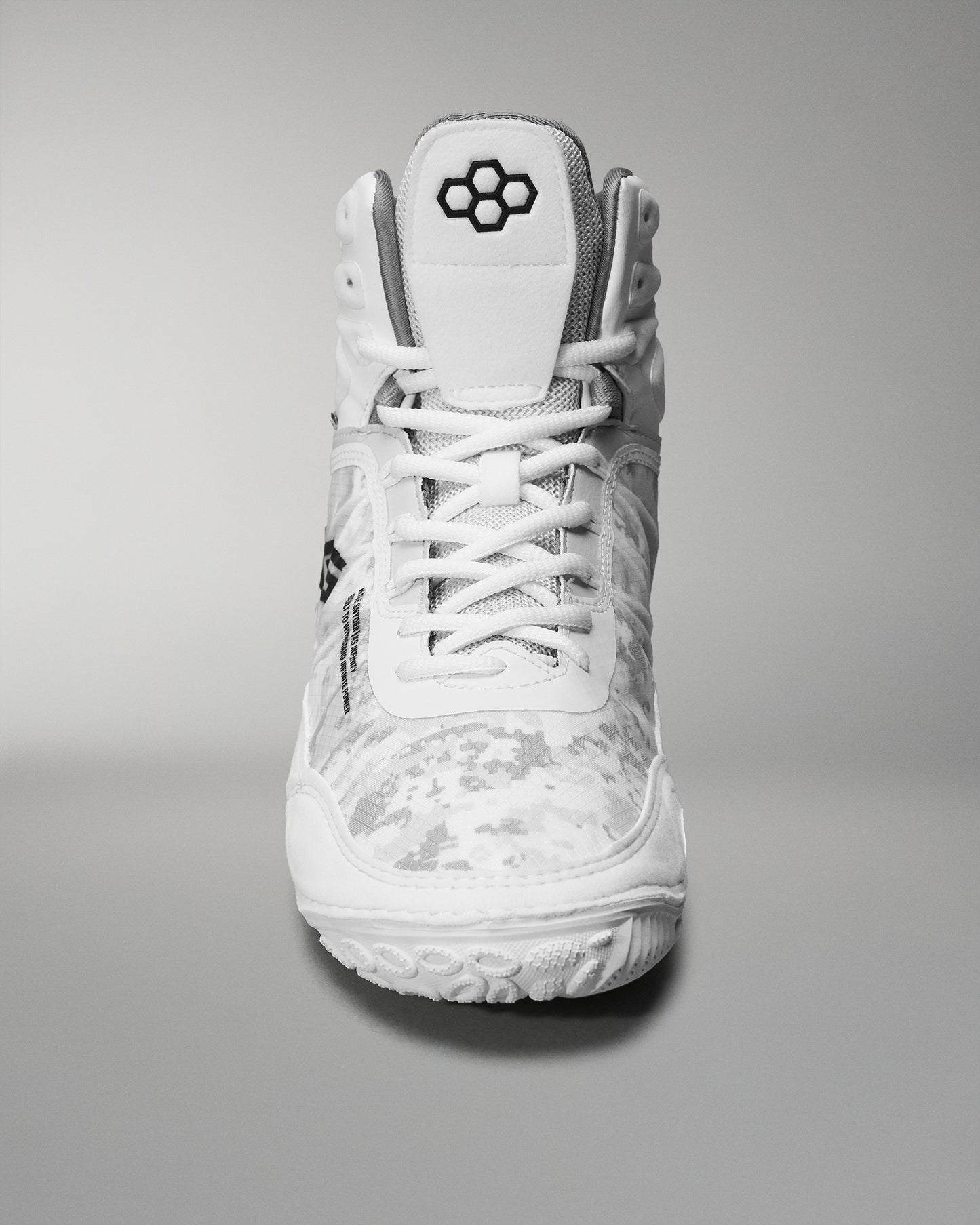 High-top athletic shoe showcases a white camo design and textured sole, featuring a padded collar and reinforced toe for sports performance.