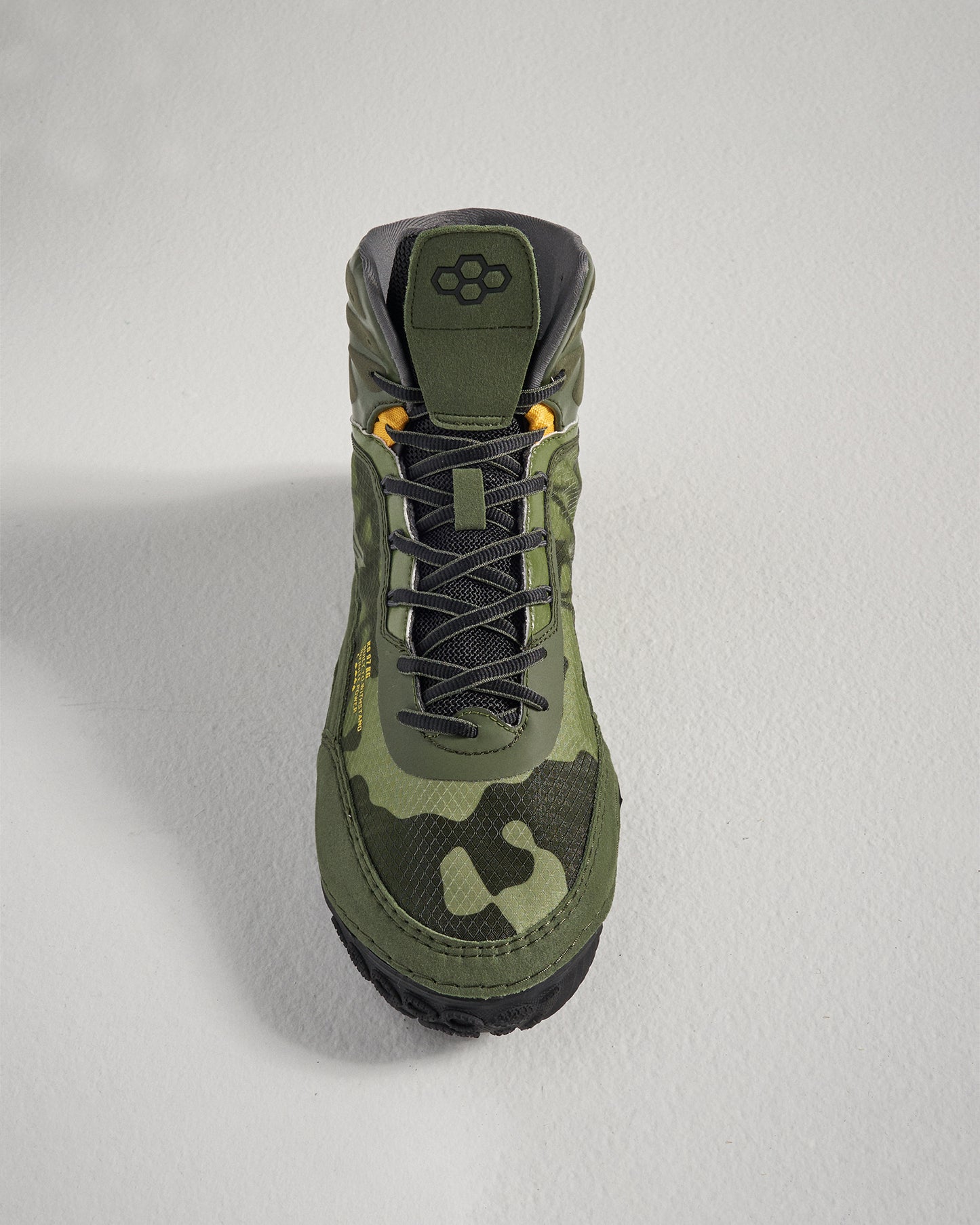 This image showcases a green camouflage high-top sneaker featuring a textured upper black accents and a rugged sole designed for outdoor activities