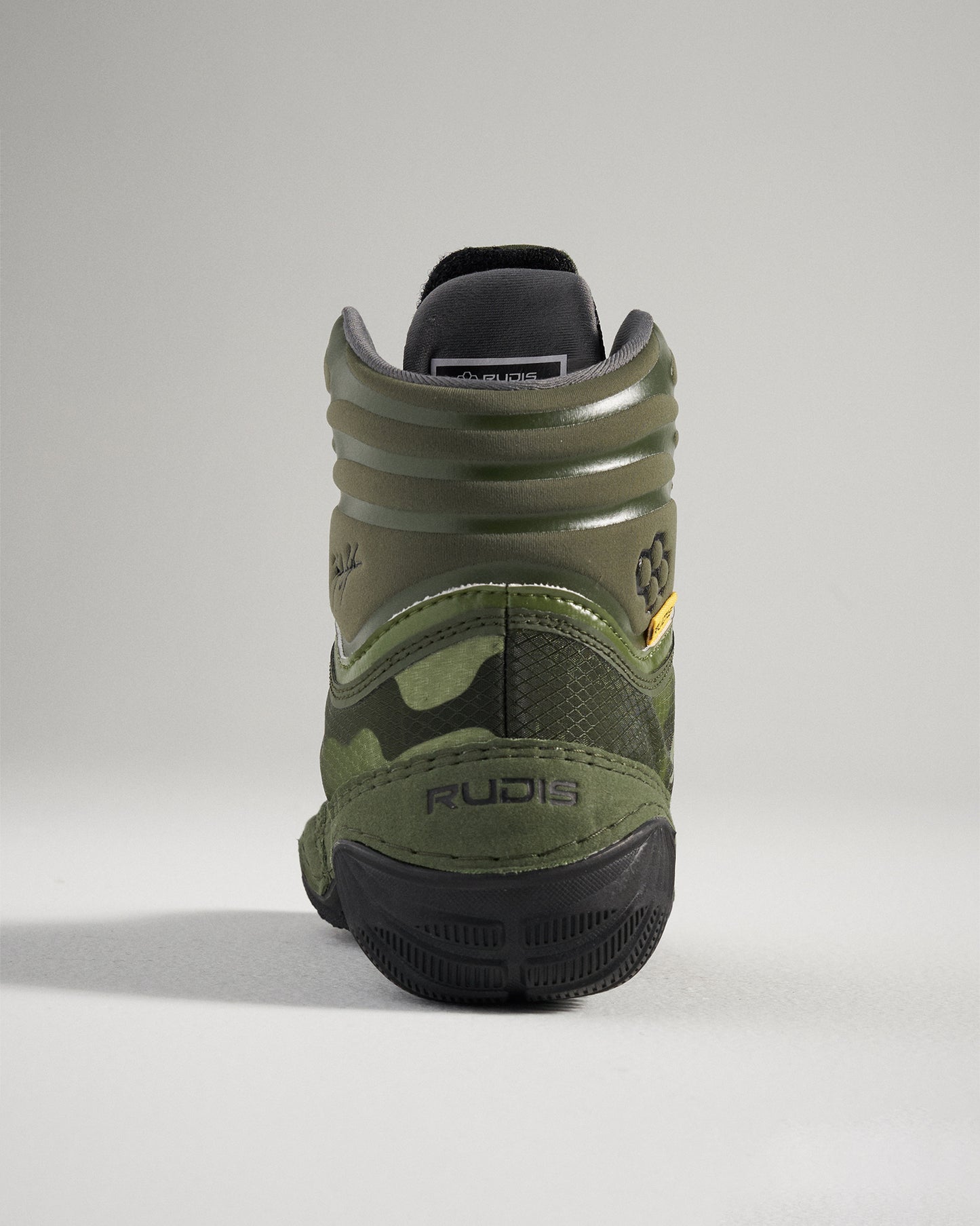 A green camouflage wrestling shoe featuring a high-top design branded details and a textured sole for improved grip during competition