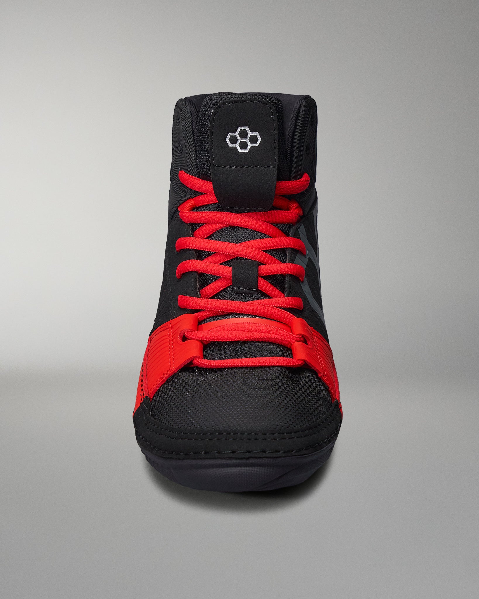 Front of shoe - Black RUDIS wrestling shoes with white logos, red accents, and textured soles for grip and agility