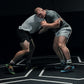 Two wrestlers engage in a competition on a marked mat showcasing their athleticism and technique under dramatic lighting