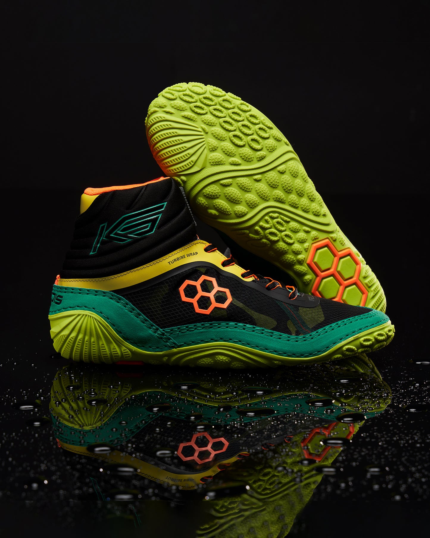 A pair of vibrant black and green athletic shoes featuring honeycomb detailing and a sleek design showcased against a reflective black surface with water droplets