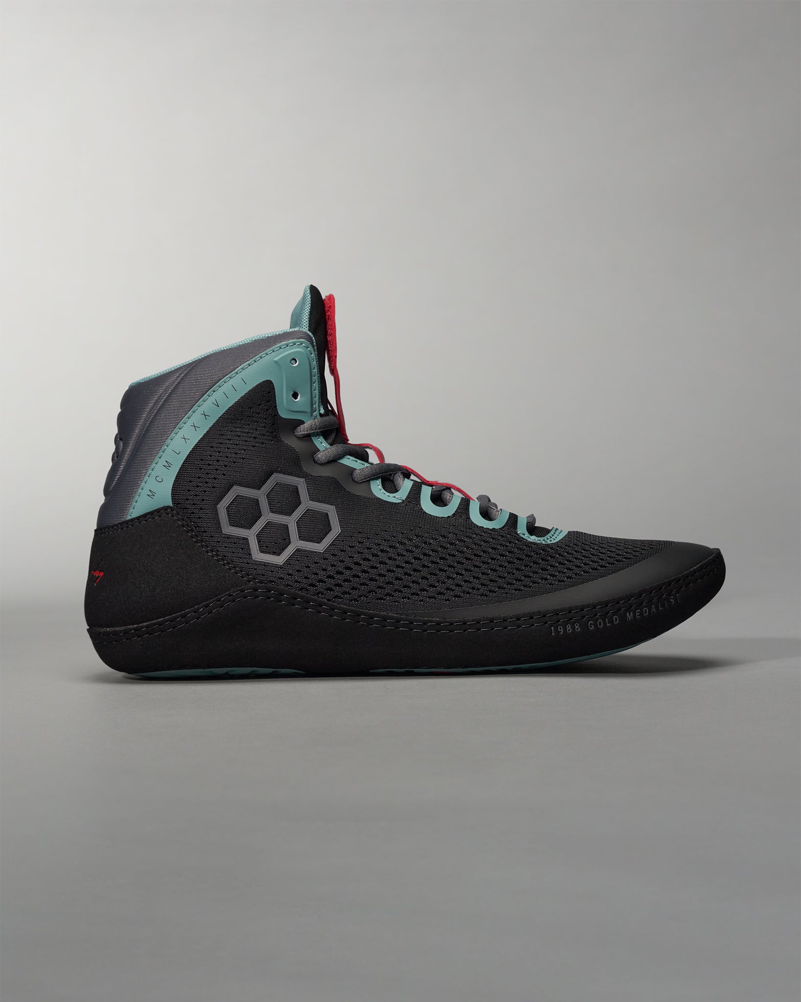 A modern black athletic shoe with turquoise and red accents featuring a breathable mesh upper and a unique hexagonal design on the side