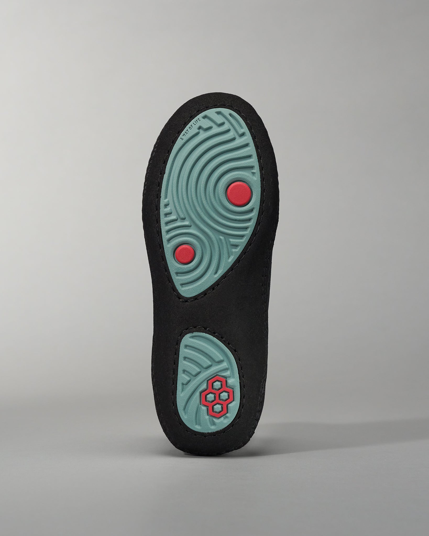 A black shoe sole featuring a textured mint green bottom and red accents for enhanced grip and style