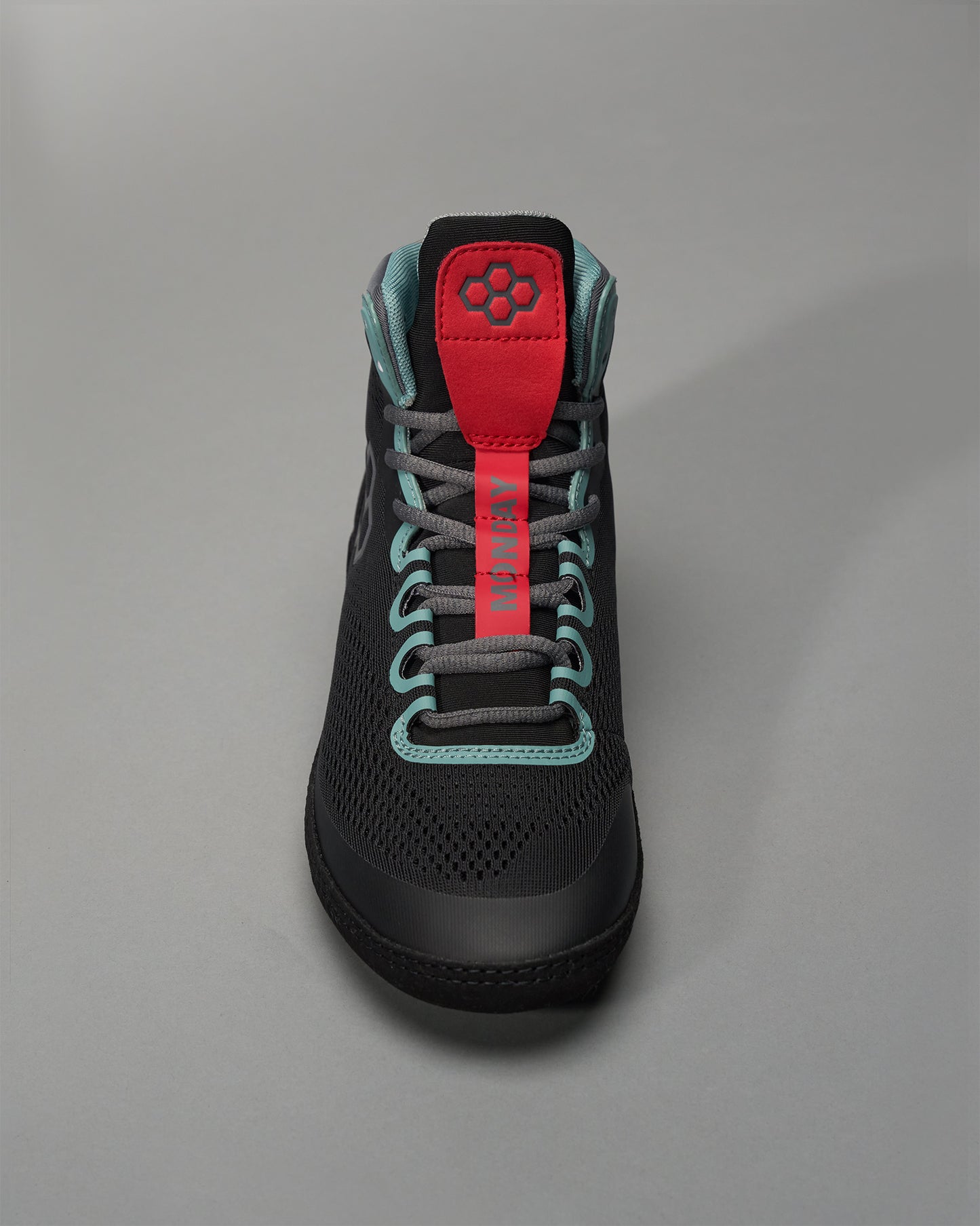 A modern black sneaker with a red and teal color scheme featuring a breathable mesh upper and stylish design elements