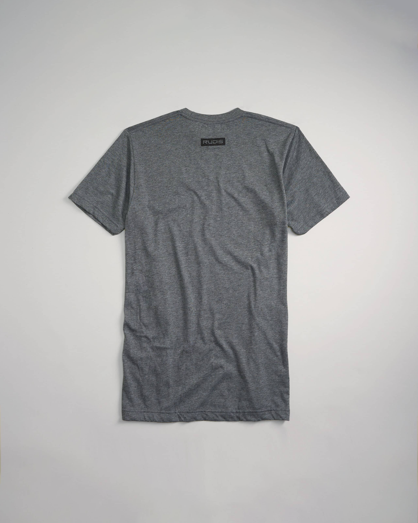 A gray short-sleeve t-shirt is displayed from the back featuring a small label with the brand name RUDIS