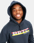 A young man smiles while wearing a dark blue hoodie featuring a colorful PRTC WRESTLING logo on the front