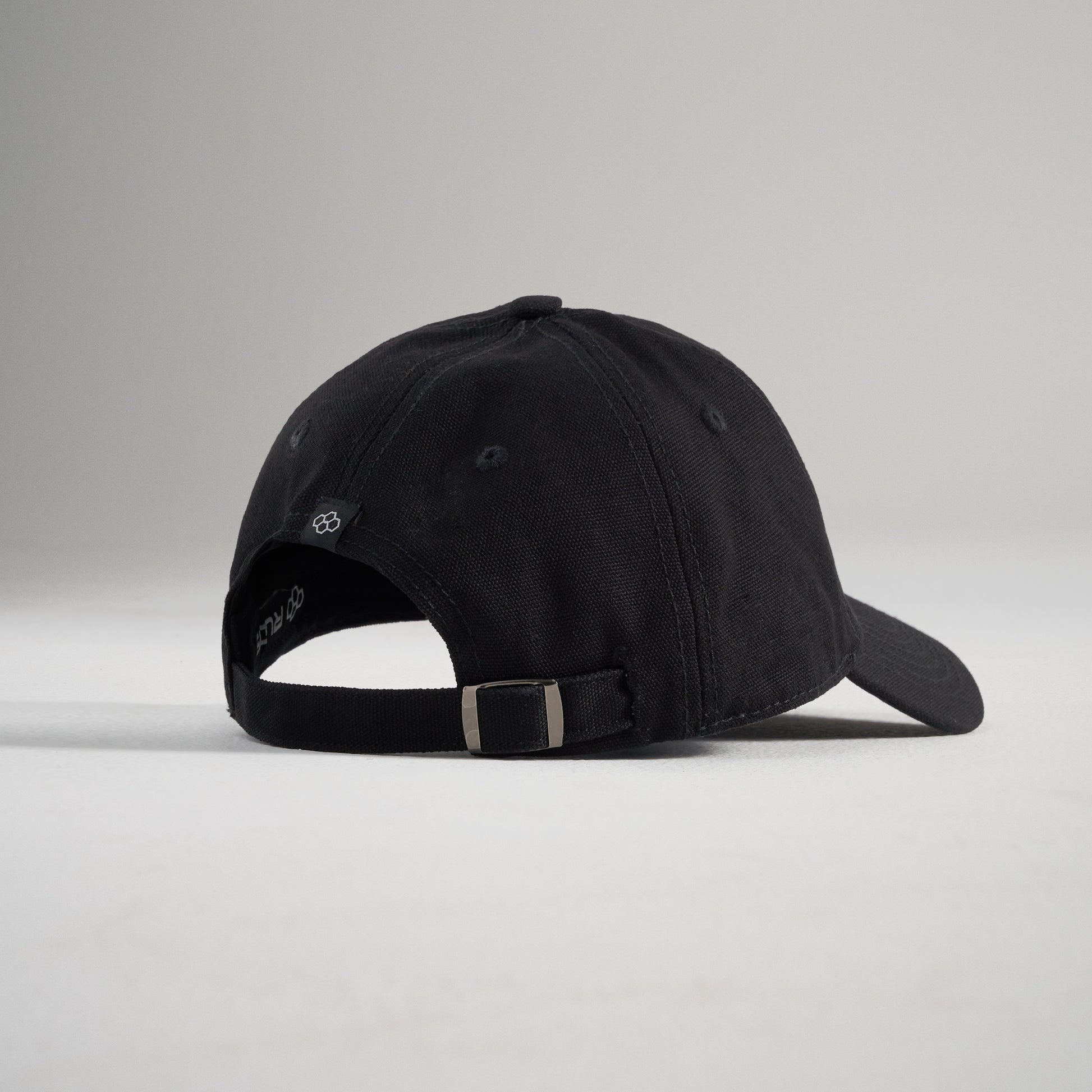 A black baseball cap viewed from the back featuring an adjustable strap and a minimalist design