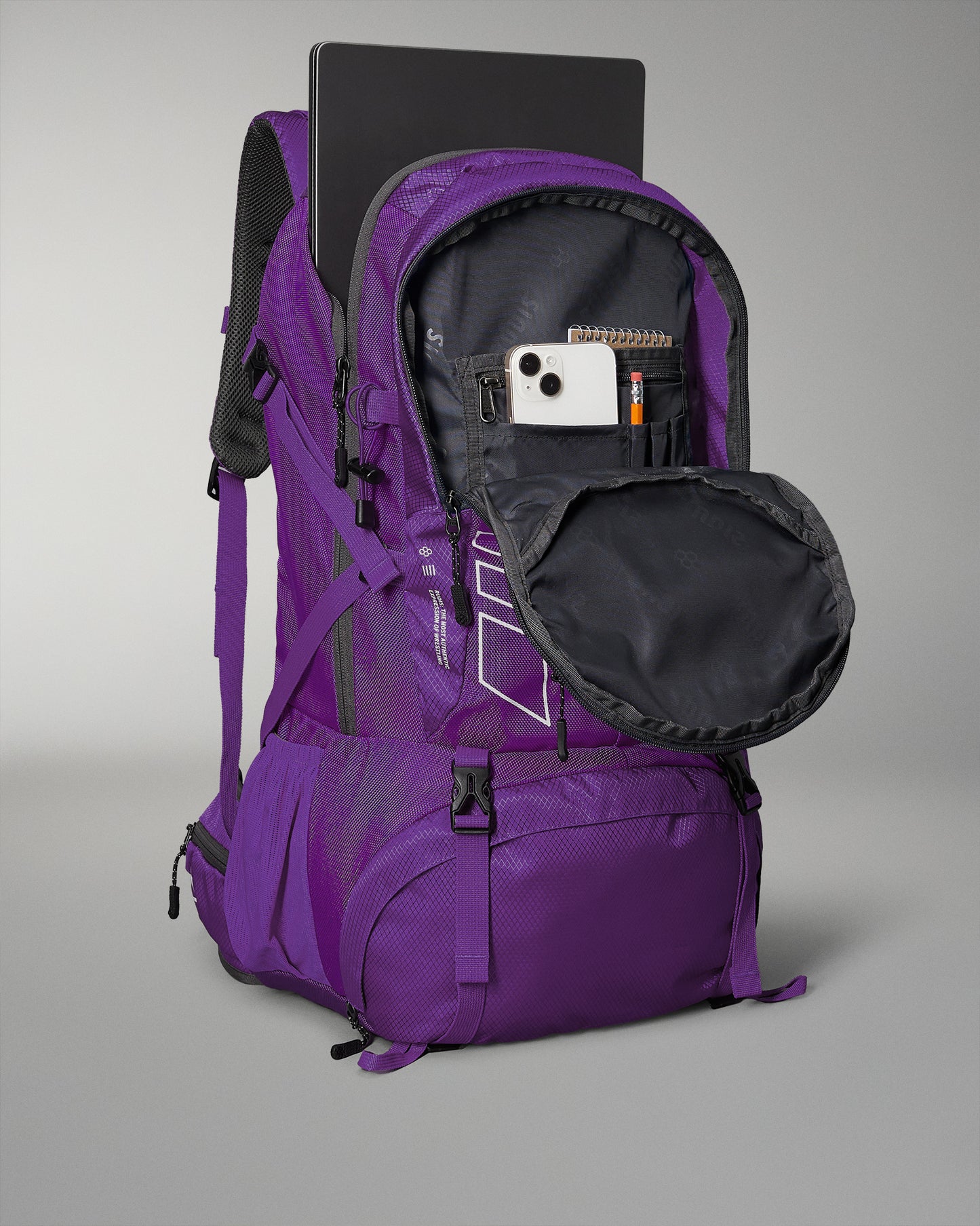 A purple backpack with a textured design features a laptop compartment and an unzipped front pocket holding a smartphone, a notepad, and a pencil, showcasing its functional and stylish nature.