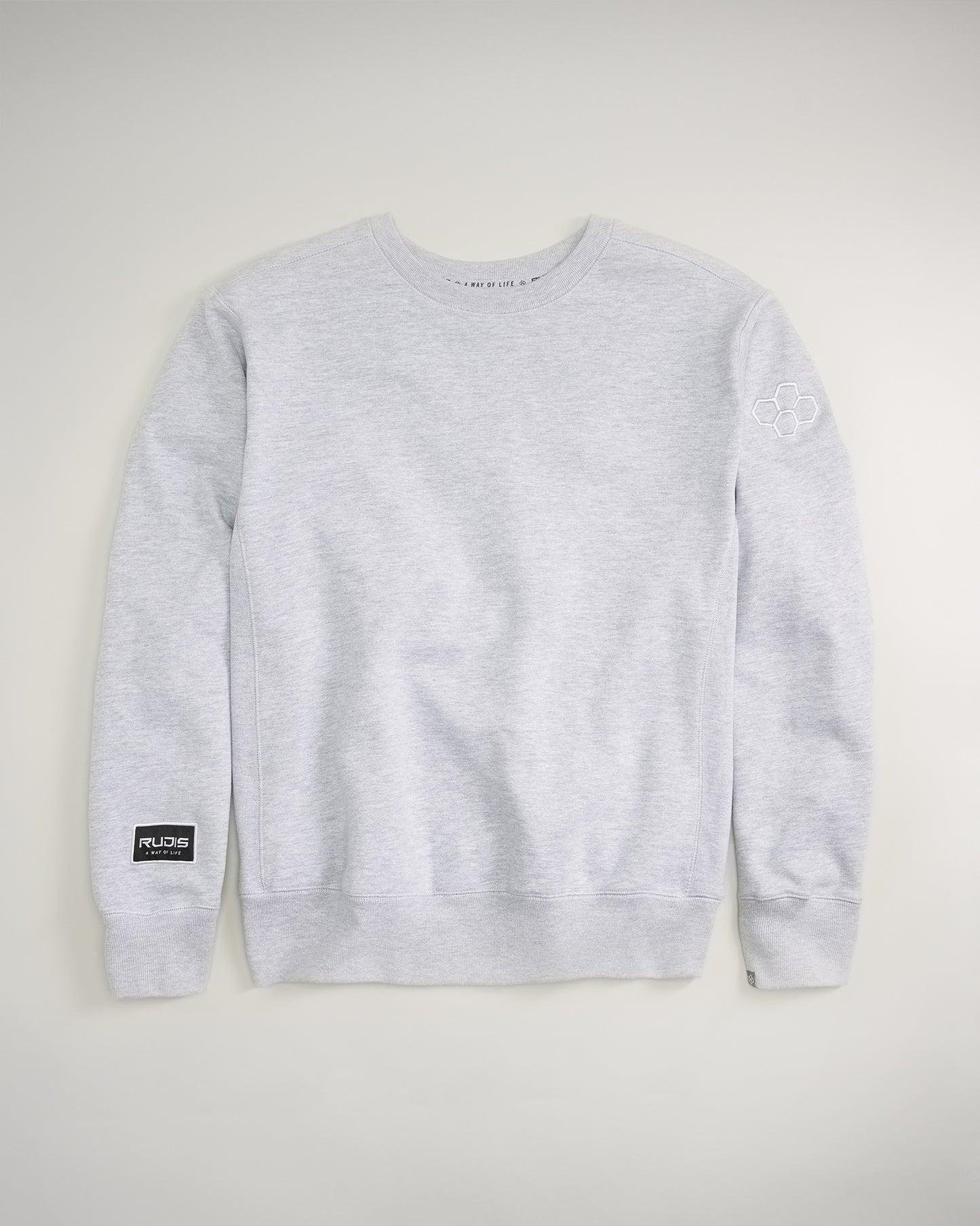 This image features a light gray sweatshirt with a round neckline and a small logo on the left sleeve